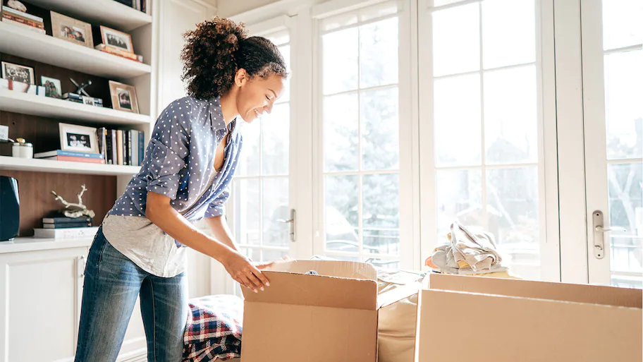 A beautiful woman packing her stuff to Sell her House Without a Realtor
