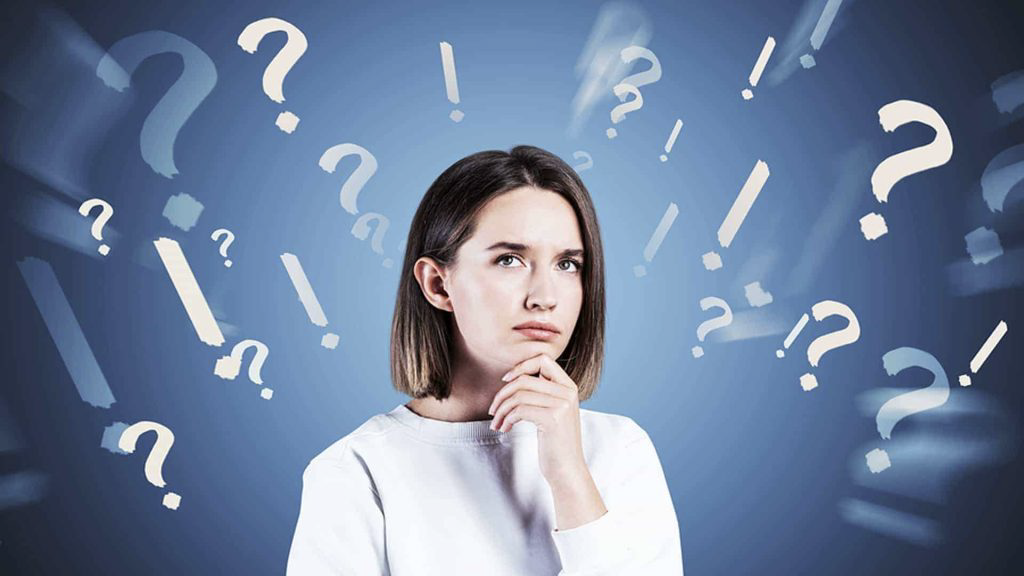 woman Lost in thought and surrounded by questions marks with blue background wondering how to Sell her House Without a Realtor
